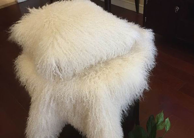 Il cuscino lanuginoso bianco dai capelli lunghi riguarda la morbidezza comoda di pelliccia tibetana dell'agnello